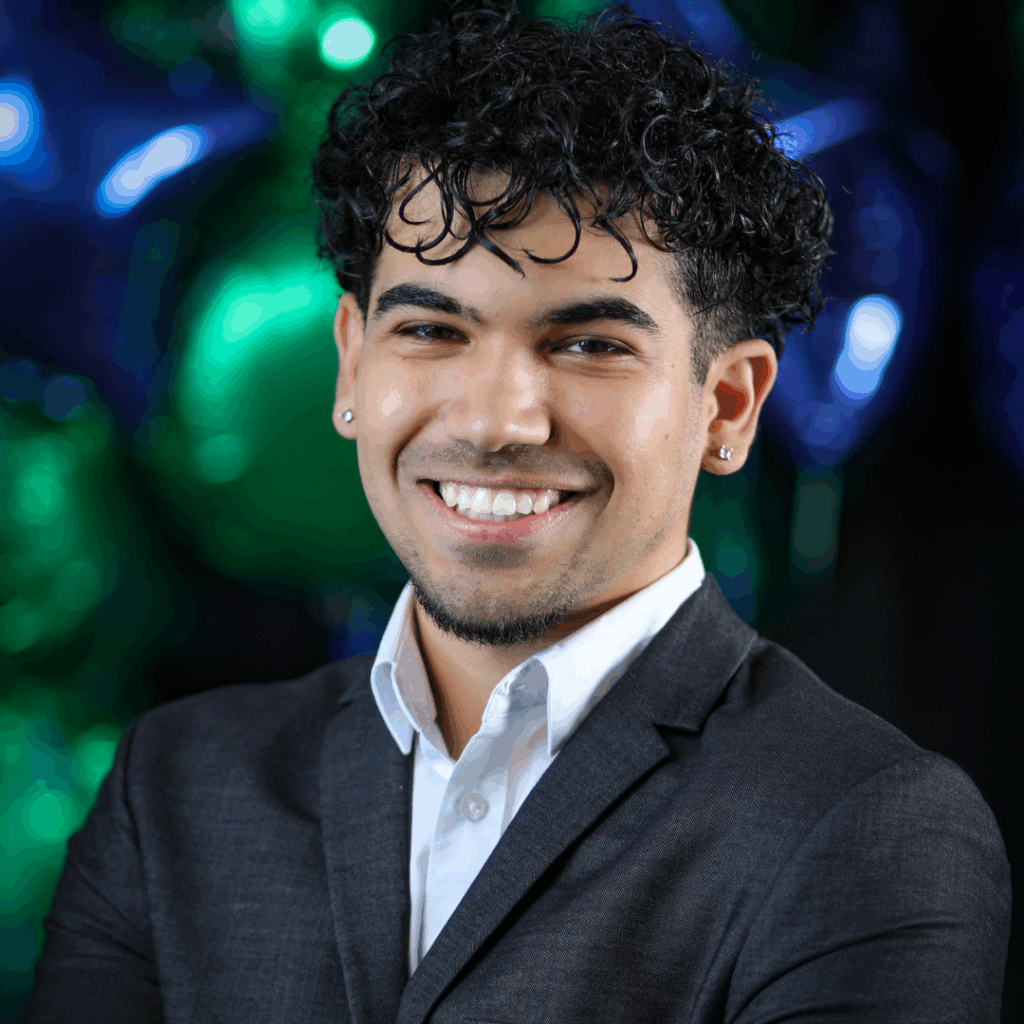 A man in black and white suit against a blue and green background