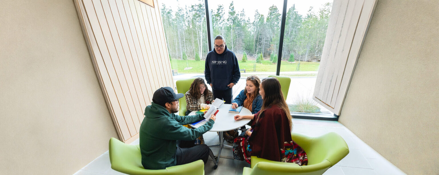 A group of students studying on a white table in the student centre