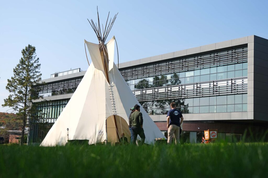 The tipi outside the library standing around it
