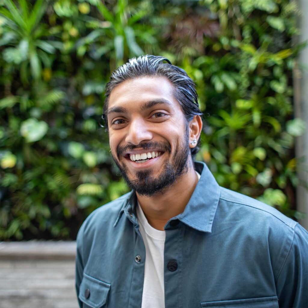 A man in white and blue shirt in front of a indoor nature background