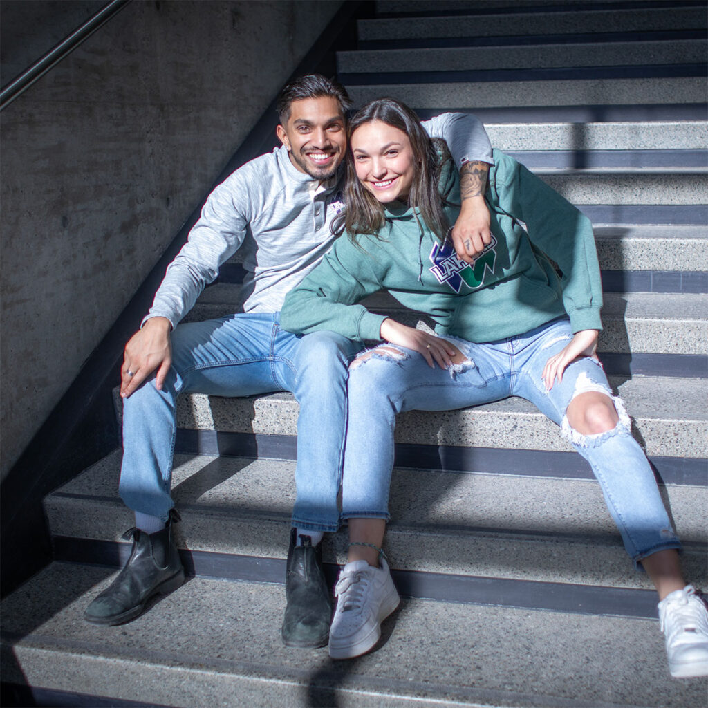 2 students smiling while sitting on some stairs